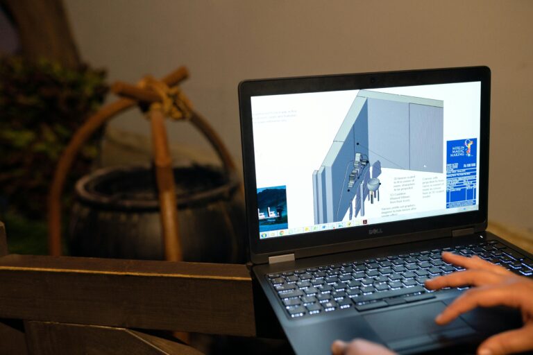 Home Engineer working on a CAD design using a laptop computer. Indoor setting highlighting technology in engineering.